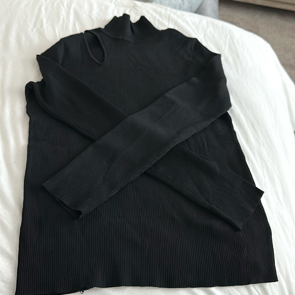 Rachel Rachel Roy black turtleneck with shouldered slit on the right side.